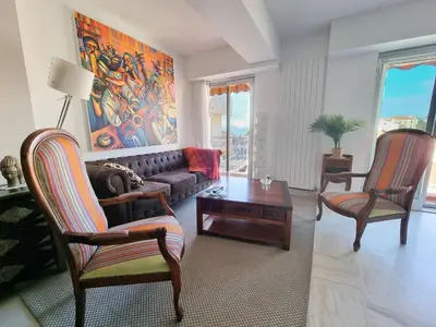 a living room with a couch and two chairs at 69m2, balcon vue mer, 2 salles de bain in Cannes
