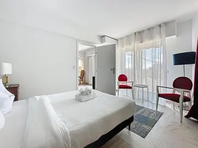 a bedroom with a bed and a table and chairs at 69m2, balcon vue mer, 2 salles de bain in Cannes
