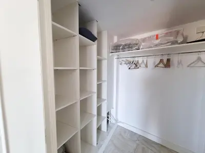 a walk in closet with white shelves at 69m2, balcon vue mer, 2 salles de bain in Cannes