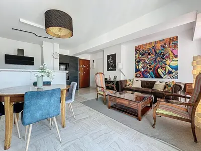 a living room with a table and a couch at 69m2, balcon vue mer, 2 salles de bain in Cannes