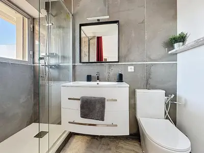 a bathroom with a sink and a toilet and a mirror at 69m2, balcon vue mer, 2 salles de bain in Cannes