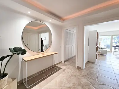 a room with a mirror on the wall and a table at 86m2, spacieux, 2 chambres, à 1 min de la plage in Cannes