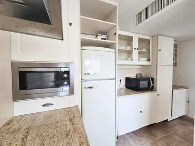 a kitchen with a refrigerator and a microwave at 86m2, spacieux, 2 chambres, à 1 min de la plage in Cannes
