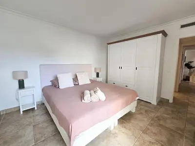 a bedroom with a bed with two white shoes on it at 86m2, spacieux, 2 chambres, à 1 min de la plage in Cannes