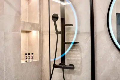 a shower with a hose attached to a wall at Celestre Croisette - Appartement de Luxe Croisette avec Terrasse et Vue Mer in Cannes