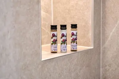 two bottles of honey on a shelf in a bathroom at Celestre Croisette - Appartement de Luxe Croisette avec Terrasse et Vue Mer in Cannes