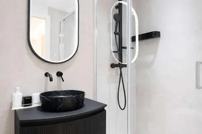 a bathroom with a black sink and a mirror at Celestre Croisette - Appartement de Luxe Croisette avec Terrasse et Vue Mer in Cannes