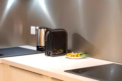 a toaster sitting on a counter next to a bowl of fruit at Celestre Croisette - Appartement de Luxe Croisette avec Terrasse et Vue Mer in Cannes