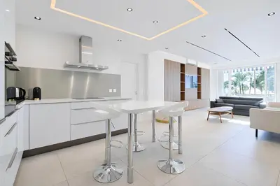 a kitchen and living room with a table and chairs at Celestre Croisette - Appartement de Luxe Croisette avec Terrasse et Vue Mer in Cannes