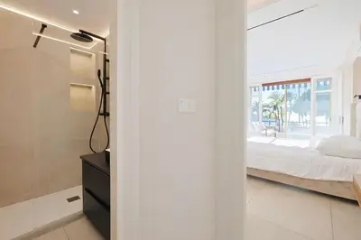 a bedroom with a bed and a large window at Celestre Croisette - Appartement de Luxe Croisette avec Terrasse et Vue Mer in Cannes