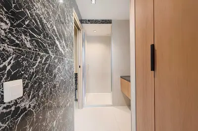 a bathroom with a black and white marble wall at Sable Croisette - Appartement de Luxe avec terrasse et vue Mer in Cannes