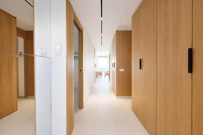 a hallway with wooden doors and a white floor at Sable Croisette - Appartement de Luxe avec terrasse et vue Mer in Cannes