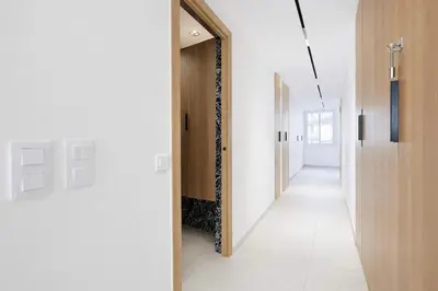 a hallway with white walls and a mirror at Sable Croisette - Appartement de Luxe avec terrasse et vue Mer in Cannes
