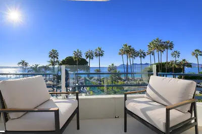 two chairs on a balcony with a view of the water at Sable Croisette - Appartement de Luxe avec terrasse et vue Mer in Cannes