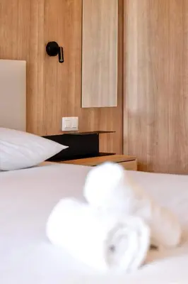 a bedroom with a white bed and a wooden wall at Prestige Croisette - Apartment with Panoramic Terrace and Sea View in Cannes in Cannes