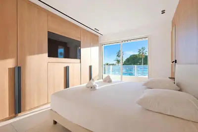 a bedroom with a large white bed with a large window at Prestige Croisette - Apartment with Panoramic Terrace and Sea View in Cannes in Cannes