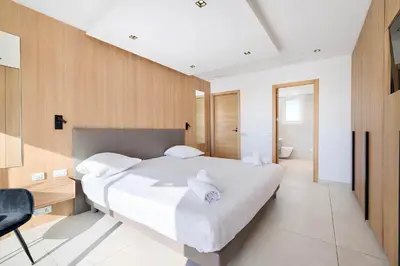 a bedroom with a large white bed and a desk at Reflet Croisette - Luxury Apartment with Terrace and Sea View in Cannes