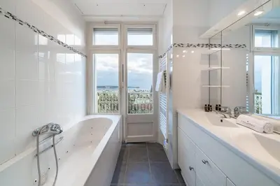 a bathroom with two sinks and a tub and a window at COZYSTAY Elegant Two-Bedroom Apartment in the 