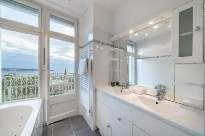 a bathroom with a tub and a sink and a window at COZYSTAY Elegant Two-Bedroom Apartment in the 