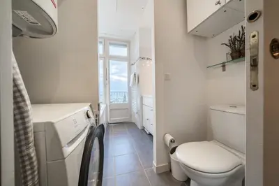 a small bathroom with a toilet and a window at COZYSTAY Elegant Two-Bedroom Apartment in the 
