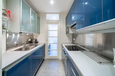 a kitchen with blue cabinets and a sink at COZYSTAY Elegant Two-Bedroom Apartment in the 