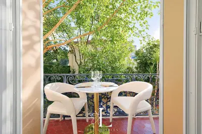 a table and four chairs sitting on a balcony at Les Lucioles 2 - Appartement Luxe Studio Balcon in Cannes