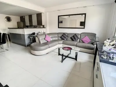 a living room with a gray couch and pink pillows at Luxueux appartements idéalement situés en plein centre ville de Cannes in Cannes