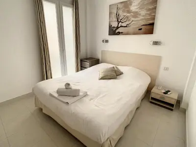 a small bedroom with a white bed and a window at Luxueux appartements idéalement situés en plein centre ville de Cannes in Cannes
