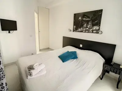a bedroom with a white bed with towels on it at Luxueux appartements idéalement situés en plein centre ville de Cannes in Cannes