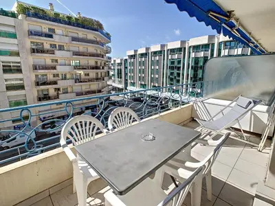 a table and chairs on a balcony with buildings at Appartements Medicis in Cannes