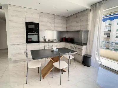 a kitchen with a table and chairs in a room at Appartements Medicis in Cannes