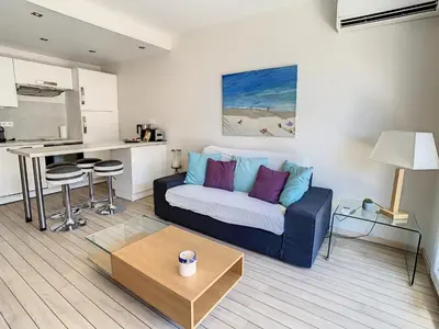 a living room with a couch and a kitchen at Appartements Medicis in Cannes