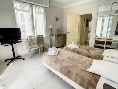 a living room with two beds and a television at Appartements Cannes Centre : Rond Point Duboys d'Angers in Cannes