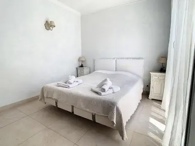 a bedroom with a white bed with towels on it at Appartements Cannes Centre : Rond Point Duboys d'Angers in Cannes