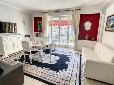 a living room with a table and a couch at Appartements Cannes Centre : Rond Point Duboys d'Angers in Cannes