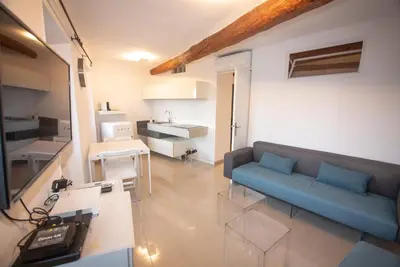 a living room with a blue couch and a kitchen at Cannes Marina by Connexion in Cannes