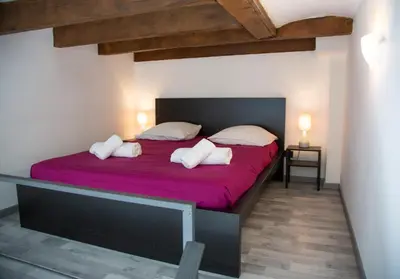 a bedroom with a large bed with purple sheets and pillows at Sweet Holiday in Cannes