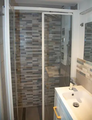 a bathroom with a glass shower with a sink at Sweet Holiday in Cannes