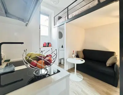 a living room with a black couch and a bowl of fruit at Croisette Studio 1 min beach in Cannes