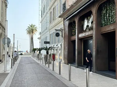 a woman standing on a street in front of a building at Croisette Studio 1 min beach in Cannes