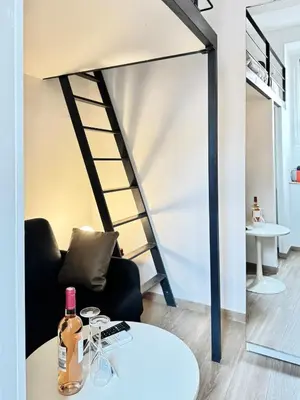 a living room with a black chair and a table at Croisette Studio 1 min beach in Cannes