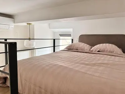 a bedroom with a large bed with pink pillows at Croisette Studio 1 min beach in Cannes