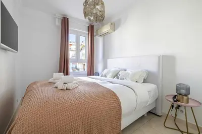 a bedroom with a bed with white sheets and a window at Splendid apartment a-c 2BR-4P - Sea View in Cannes