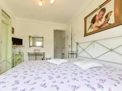 a bedroom with a large bed with purple flowers at Apartment Boite d'Amour Wohnung mit Terrasse und Solarium by Interhome in Cannes