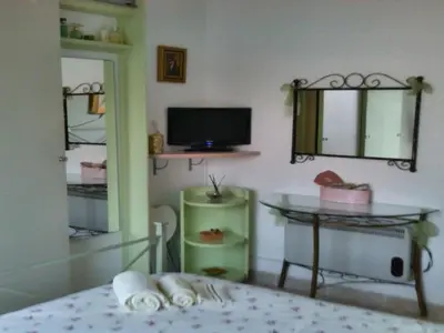 a room with a bed and a table and a television at Apartment Boite d'Amour Wohnung mit Terrasse und Solarium by Interhome in Cannes