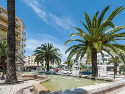 a city street with palm trees and a fountain at Apartment Boite d'Amour Wohnung mit Terrasse und Solarium by Interhome in Cannes