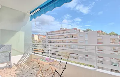 a balcony with a table and chairs and a building at Appartement Vallombrosa proche Plages et Palais in Cannes