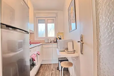 a kitchen with a table with a laptop on it at Appartement Vallombrosa proche Plages et Palais in Cannes