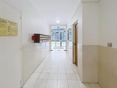an empty hallway with white tile floors and a door at 2 bedroom Pradignac 305 in Cannes