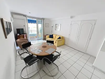 a living room with a table and chairs at 2 bedroom Pradignac 305 in Cannes